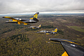 Russia - 29 September 2013: Aerial view of military jets in formation above a scenic forest landscape under a cloudy sky, Smolensk region, Russia.