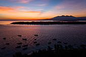 Aerial view of boats and mountains at sunset off Gili Islands, Indonesia.