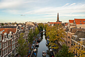 Aerial view of a boat sailing in Amsterdam canal at sunset, Amsterdam, The Netherlands.