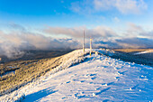 Panoramic view of a winter landscape with windmill and antenna at sunset, Black Forest, Germany.