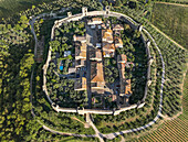 Luftaufnahme der mittelalterlichen Burg und der ummauerten Stadt Siena, umgeben von wunderschönen Feldern in der Provinz Siena, Italien.