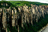 Luftaufnahme der majestätischen Lenasäulen-Felsformationen, umgeben von einem ruhigen Wald und schroffen Felsen, Lenasäulen-Nationalpark, Jakutische Republik, Russland