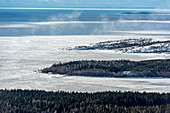 Luftaufnahme des zugefrorenen Ladogasees, umgeben von ruhigen Wäldern und schneebedecktem Eis, Republik Karelien, Russland