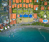 Aerial view of luxury hotel, fish farm and traditional pump boats, Gerokgak, Bali.