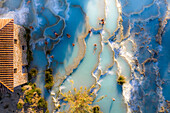 Aerial view of Saturnia spa with sunbathers at Hot Spring, Manciano, Grosseto, Italy.