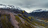 Luftaufnahme einer schönen Gebirgslandschaft mit Schnee auf den Gipfeln im Austurland, Island.
