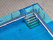 Aerial view of a tranquil public pool with blue tiles and modern geometric design, Oberschoneweide, Germany.