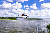 Aerial view of kiteboarder doing kiteloop backroll high in the air, Svencele, Lithuania.