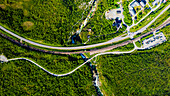 Luftaufnahme einer malerischen Schlucht mit Eisenbahnschienen und Autos entlang des üppigen Abiskojakka-Flusses, Abisko-Nationalpark, Schweden.