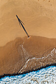 Aerial view of woman in silhouette on the beach in early morning, Hiriketiya, Sri Lanka.