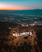Los Angeles, United States - 25 July 2018: Aerial view of the Hollywood sign on the hilltop at sunset with Los Angeles skyline in background, California, United States.