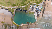 Aerial view of the beautiful bathing pool and ocean with rocky cliffs and sandy beach, Bude, United Kingdom.
