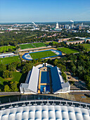 Aerial view of public pools and sports facilities surrounded by greenery and urban landscape, Westend, Germany.