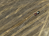 Aerial view of cereal harvesters and tractors at a farm in Oderbruch, Brandenburg, Germany.