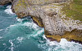 Luftaufnahme der Wellen, die in der Nähe von Puertas de Vidiago, Asturien, Costa Verde, Spanien, gegen die Küste schlagen