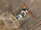 Aerial view of cereal harvesters and tractors at a farm in Brandenburg, Germany.
