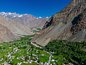 Luftaufnahme eines schönen Bergtals mit einem ruhigen Dorf und grünen Feldern, Laspur, Pakistan.