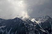 Aerial view of snowy mountains and clouds in Kashmir region, Pakistan.