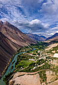 Luftaufnahme des malerischen Phander-Tals mit majestätischen Bergen, einem ruhigen Fluss und einem abgelegenen Dorf, Gilgit Baltistan, Pakistan