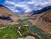 Luftaufnahme des atemberaubenden Phander-Tals mit üppigen Feldern, einem ruhigen Fluss und majestätischen Bergen, Phander, Pakistan.