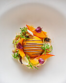 Gourmet dish with crab meat, pumpkin and black garlic