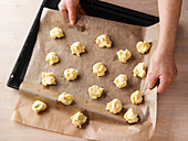 Vorbereitetes Gebäck auf Backpapier legen, später aus das Blech ziehen