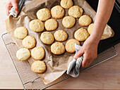 Fertiges Gebäck mit dem Backpapier auf Abkühlgitter ziehen