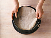 Zugeschnittenes Backpapierstück glatt auf den Springformboden legen