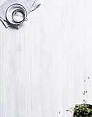 Coarse sea salt and oregano on a white glazed wooden base