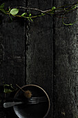 Black wooden background, twigs, plates, cutlery