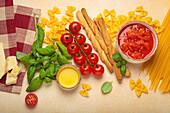 Italian ingredients - tomato sauce, grissini, pasta, basil, parmesan and olive oil