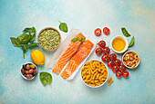 Raw salmon fillets, pasta, olives, nuts and vegetables