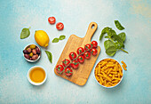 Ingredients for Italian pasta dishes - tomatoes, olives, basil, oil