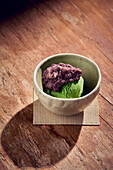 Matcha green tea ice cream topped with sweet azuki beans, traditional Japanese dessert served on ceramic dish