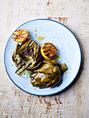 Grilled artichokes with lemon halves