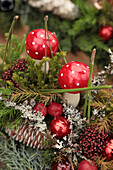 Weihnachtliches Gesteck mit Fliegenpilzen und Tannenzweigen