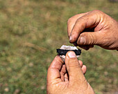 A man demonstrates placing the char cloth on the fling for starting a fire with flint and steel at the Fort Bridger Mountain Man Rendezvous in Wyoming.