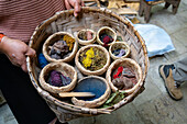 A woman shows sources for natural dye colors in the Tahuantinsuyo Weaving Workshop, Otavalo, Ecuador.