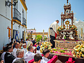 Carrión, Spain, June 19 2025, The priest ascends the float to retrieve the Blessed Sacrament in Carrión, surrounded by the faithful during the Corpus Christi event.