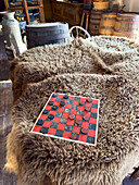 Antique checker board in sutler W.A. Carter's commissary store from the 1800s at the Fort Bridger Historic Site in Wyoming. The board is laying on buffalo hides.