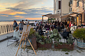 People enjoying the sunset views from a cafe terrace in Ortigia, Sicily