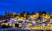 Illuminated medieval Muslim fortress stands proudly over the town of Alcala de Guadaira during a calm night in Andalusia.