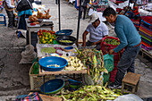 Men selling corn and other produce in the open market in Otavalo, Ecuador.