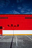 Exterior view of a parking lot and a red commercial building in Pilas, Seville.