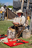 A man in period mountain man dress shows how to make leather Native American moccasins at the Fort Bridger Rendezvous in Wyoming.