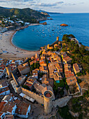 Luftaufnahme der Festungsmauern der ikonischen Burg aus dem 12. Jahrhundert und des Strandes, Tossa de Mar, Girona, Spanien