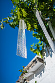 Crochet fabric hanging from a tree in UNESCO World Heritage site Rione Monti trulli district in Alberobello, Puglia, Italy