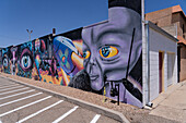 A painted mural of an alien and space craft on the side of a business in Roswell, New Mexico.