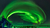 This is a 180º panorama of the Northern Lights across the northern sky on February 27, 2025 during a Kp4-level display. The Big Dipper is right of centre, while Polaris is at centre embedded in the auroral arc. Cassiopeia is at lower left in the nothwest. The aurora shows a complex of a classic arc with many swirls and sub-arcs to the north. In the distance to the northeast at lower right are some faint red structures.