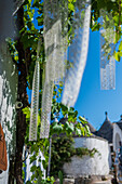 Crochet fabric hanging from a tree in UNESCO World Heritage site Rione Monti trulli district in Alberobello, Puglia, Italy